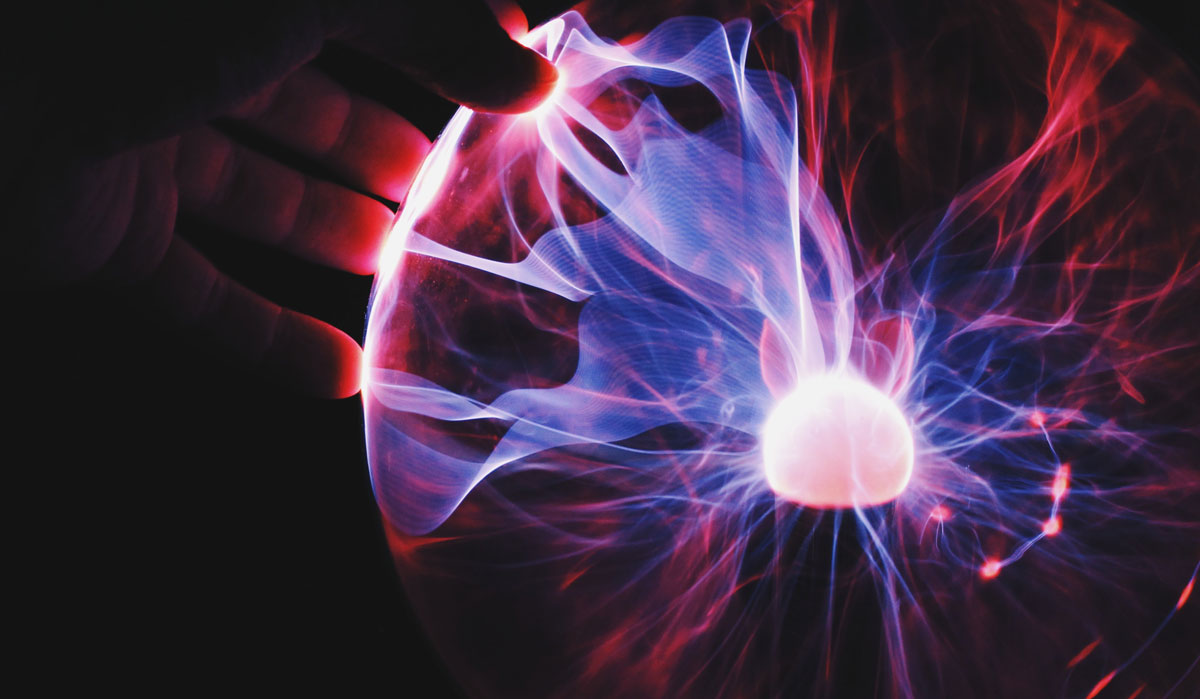 image of a hand touching a plasma globe